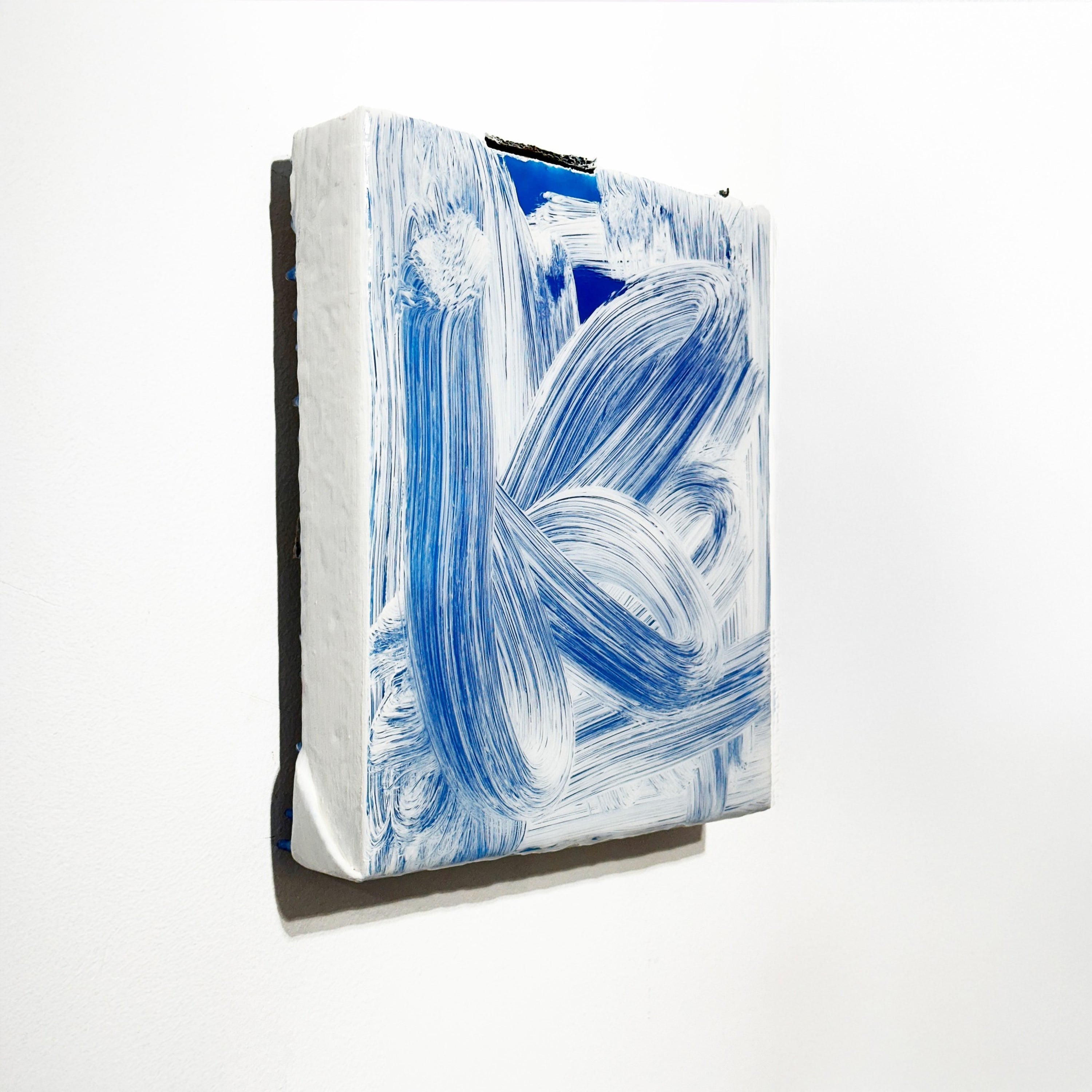 Abstract art piece with blue and white brush strokes on a white background