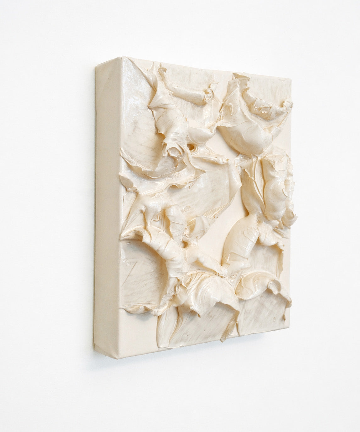Textured cream-colored wall art on a white background