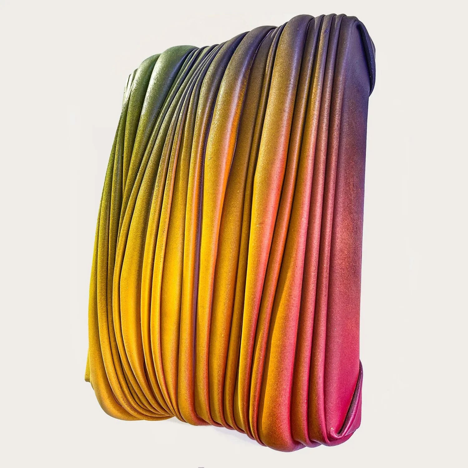 Colourful folded acrylic and varnish paint skin, pleated over canvas and stretcher with a gradient colouring in front of a white background